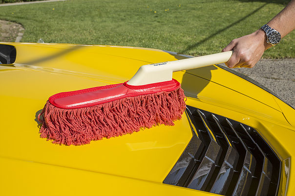 Man dusting off Corvette hood photo